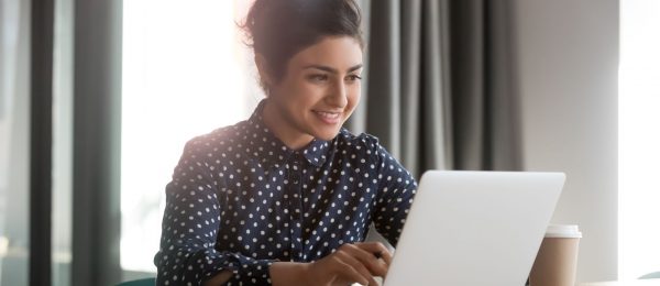 happy young woman smiling at laptop