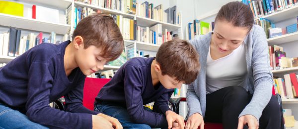 two children and lady in library